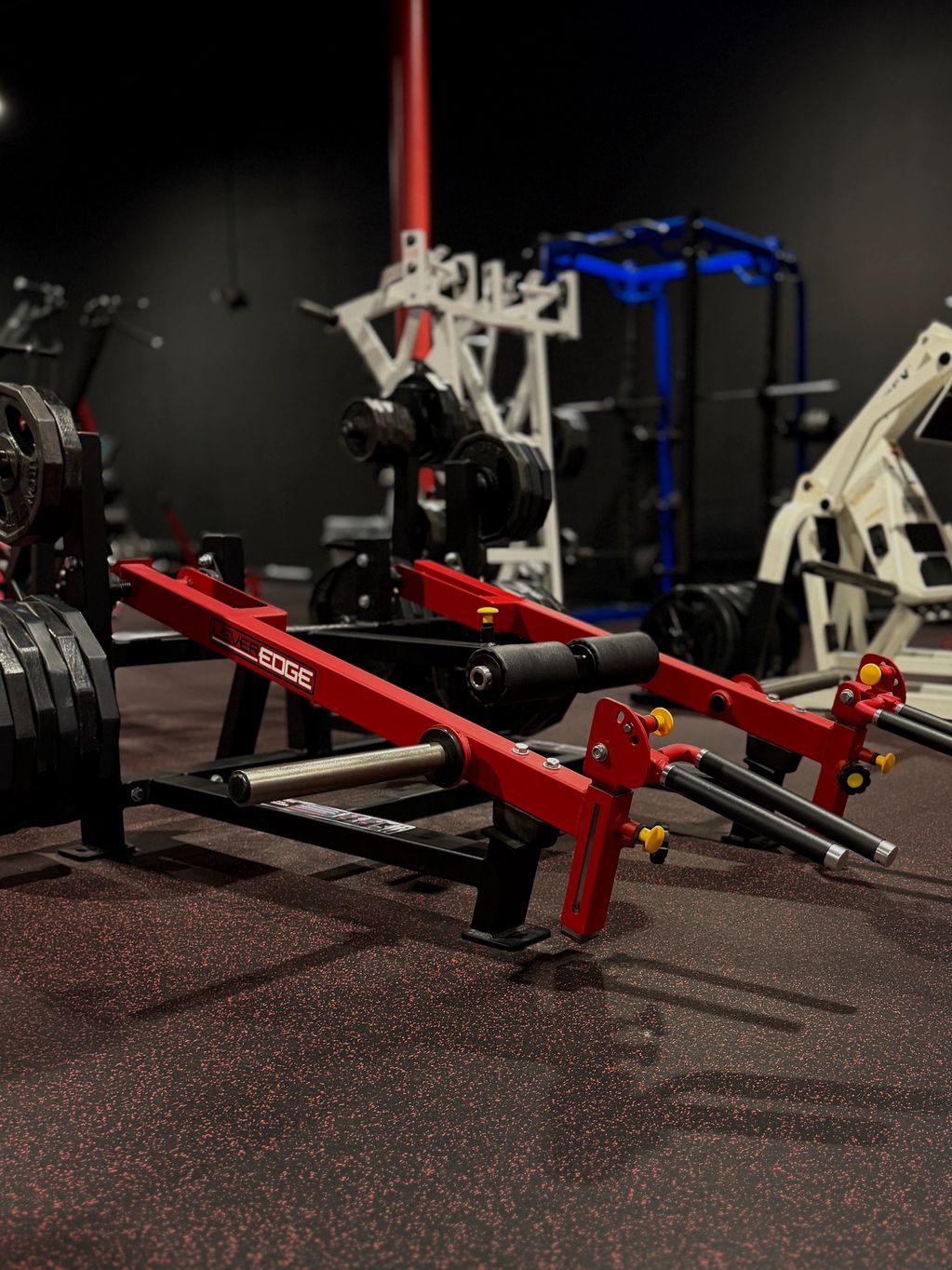 Red and black gym equipment in a dimly lit workout space.