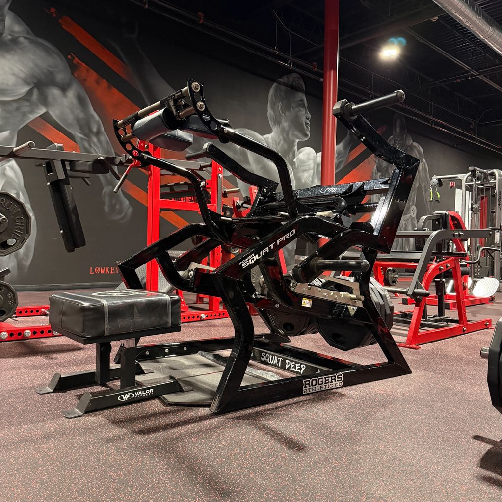 Black and red gym equipment for deep squats with padded support.