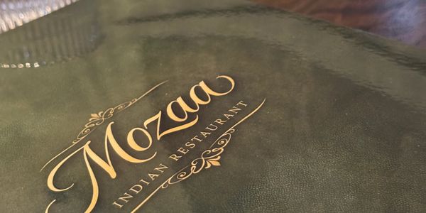 Close-up of Mozaa Indian Restaurant menu cover.