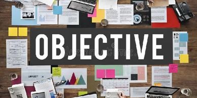 Word 'OBJECTIVE' surrounded by papers and office supplies.