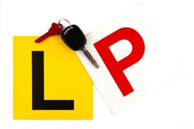 Car key on learner and probationary driver license plates.