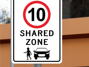 Speed limit sign indicating a 10 km/h shared zone.
