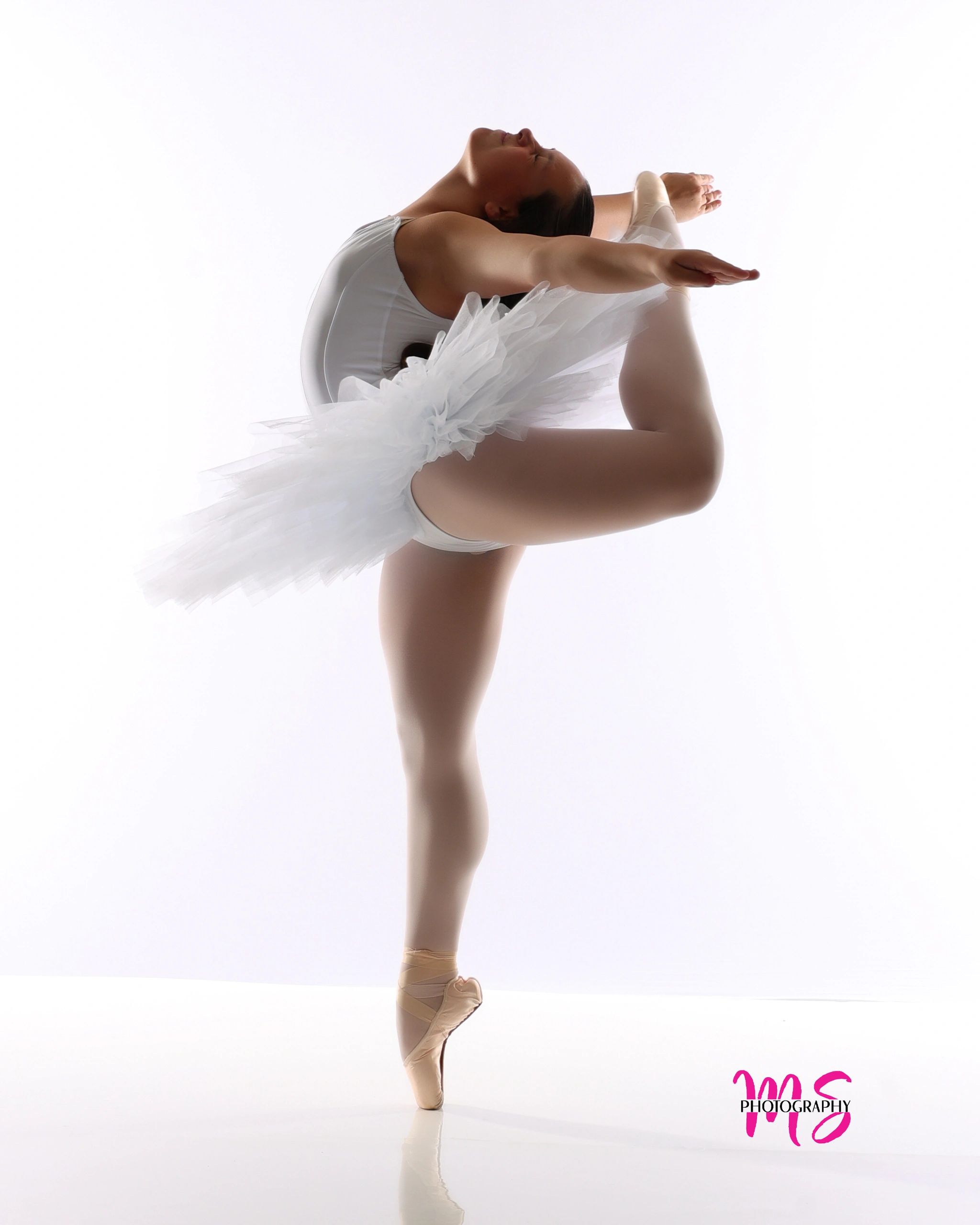 Ballet dancer performing a backbend with a leg raised.