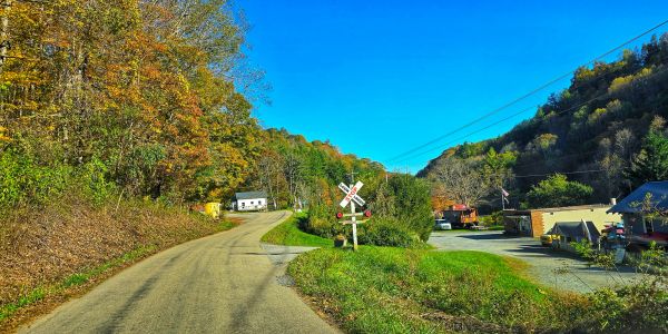 Country road with railroad crossing sign on a bright sunny day.