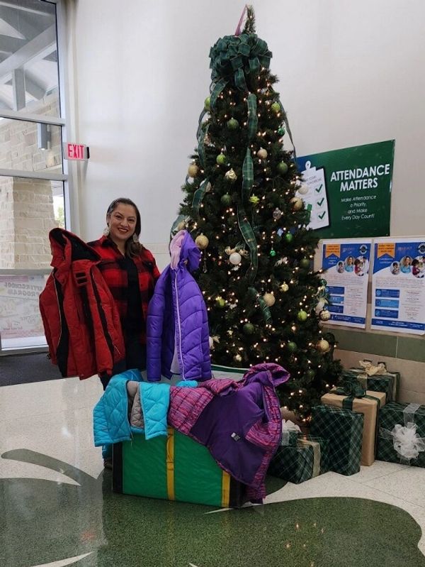 a woman standing near a Christmas tree with jackets 