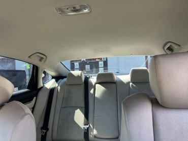 View of the backseat and rear window of a car.