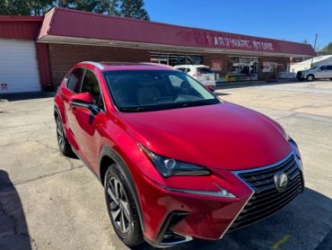 Red Lexus SUV parked outside a building.