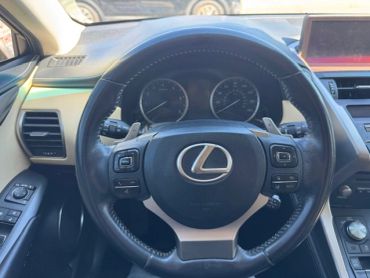 Steering wheel inside a Lexus car with dashboard and controls visible.