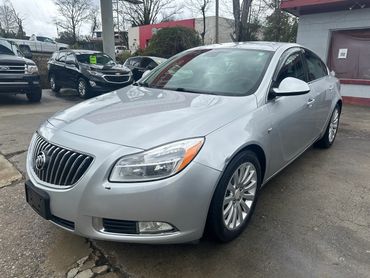 Silver Buick sedan parked outdoors on a cloudy day.