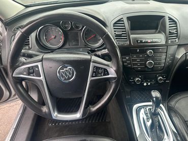 Interior view of a Buick car focusing on the steering wheel and dashboard controls.