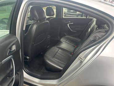 Backseat interior of a silver car with black leather seats.
