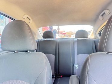 Interior view of a car showing front and back seats with seatbelts.