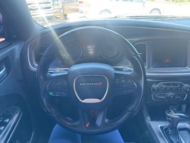 Interior view of a Dodge car steering wheel and dashboard.