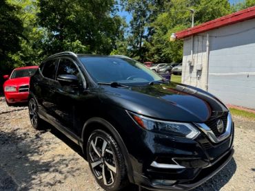 Black Nissan SUV parked outdoors on a sunny day.