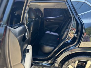 Inside view of a car's back seat with black leather upholstery.