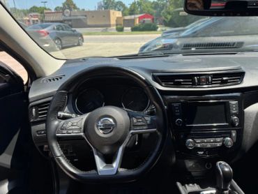 Interior view of a Nissan car steering wheel and dashboard.