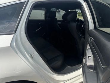 Interior view of a car's backseat with door open.