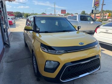 Yellow Kia Soul parked outdoors on a sunny day.