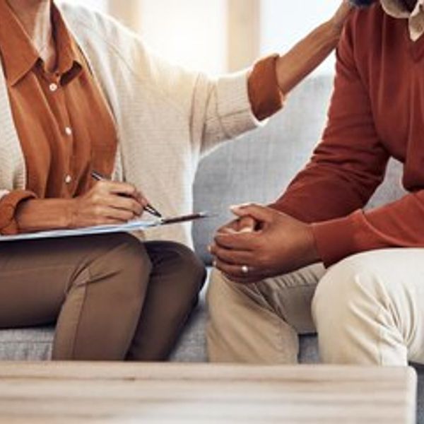Therapist comforting a client during a session.