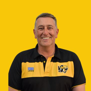 Smiling man in black and yellow polo shirt.