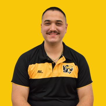 Man in black and yellow sports shirt smiling at the camera.