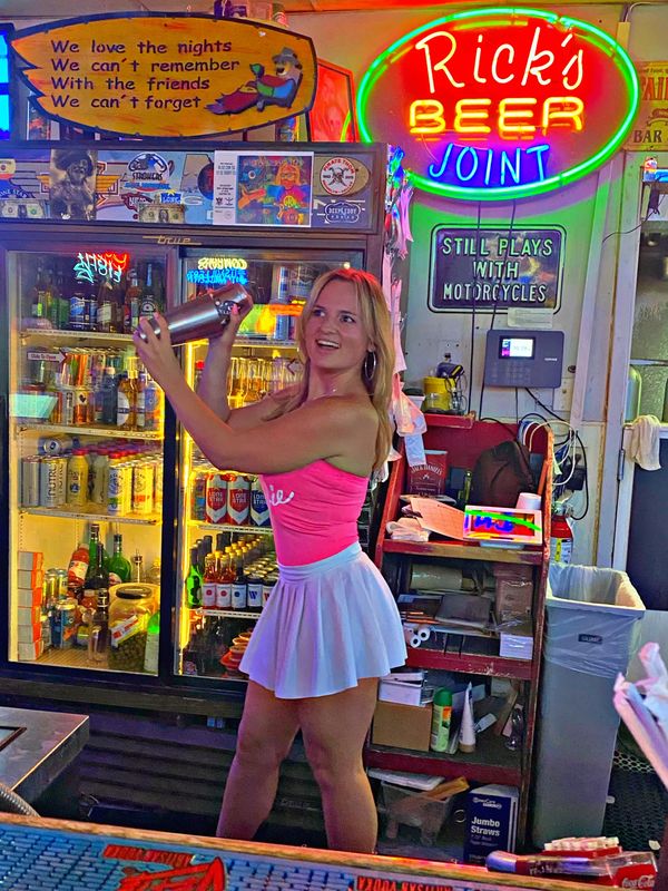 blonde girl making a shot ar a bar