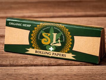 A box of SL organic hemp rolling papers on a wooden surface.