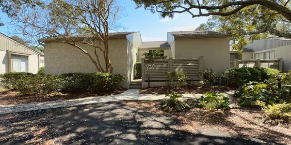 exterior of vill with sun coming through live oak trees in Lagoon Villas, HHI