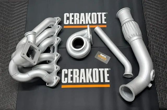 Cerakote-coated automotive exhaust components arranged on a branded mat.