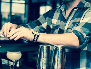 Bartender creating cocktail for guests.