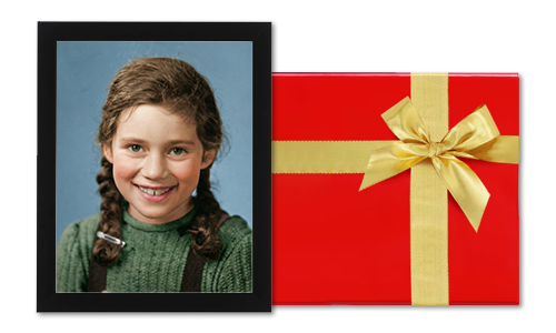 Framed photo of a smiling girl next to a red gift box with a golden ribbon.