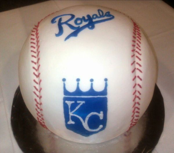 A baseball-themed cake with Kansas City Royals logo and stitching.