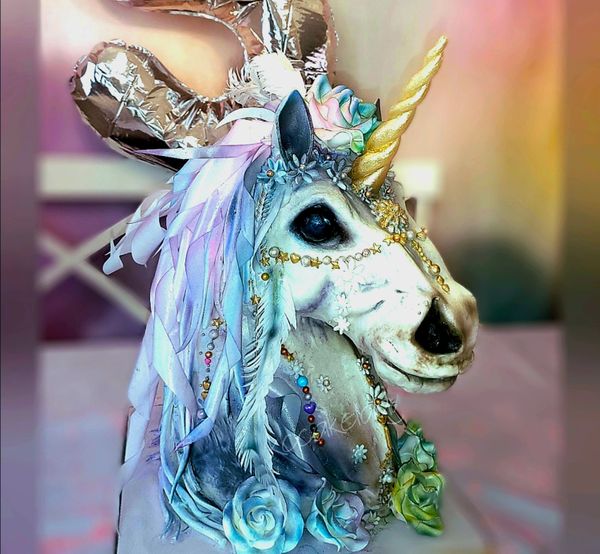 Decorative unicorn head with pastel flowers and golden horn.