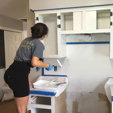 Brooke Faust hard at work painting cabinets in a rental property.