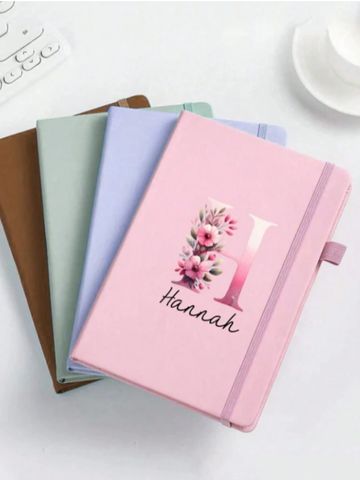 Stack of colorful notebooks with one personalized.