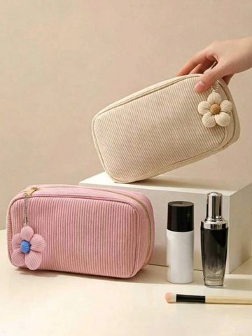 Two floral-themed makeup pouches with cosmetic bottles and a brush.