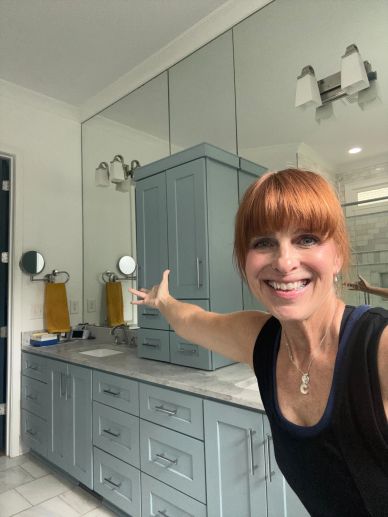 Woman happily showing remodeled bathroom vanity.