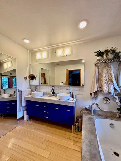 Modern bathroom with blue vanity and bathtub.