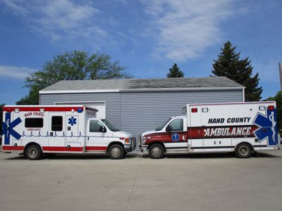 Two Hand County ambulances parked facing each other.