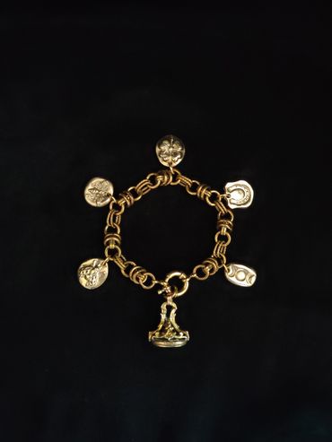 Charm bracelet. Antique brass & amethyst glass fob with handmade antique inspired charms.
Etsy Shop 