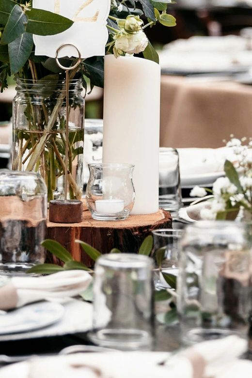 Rustic table centerpiece with candles and flowers.