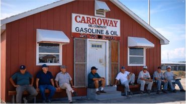 Seven men sitting outside a vintage Carroway Oil Company gas station.