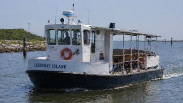 A small ferry boat named Carroway Island on calm waters.