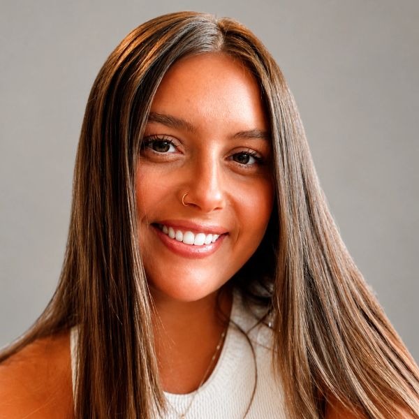 Smiling young woman with long straight hair and a nose ring.