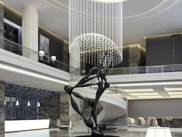 Modern lobby with a sleek black sculpture and elegant chandelier.