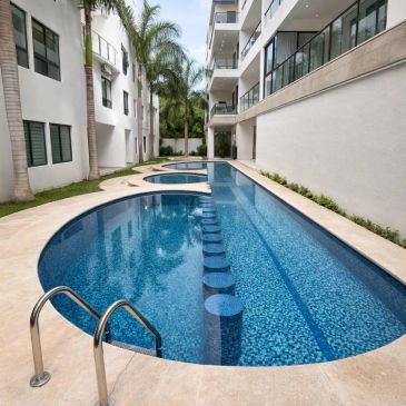 Piscina moderna entre edificios residenciales con palmeras.