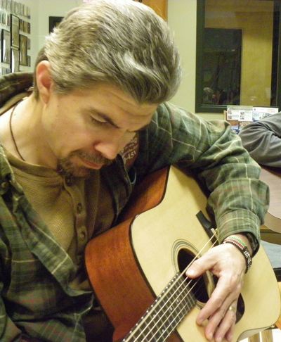 Man playing guitar indoors.