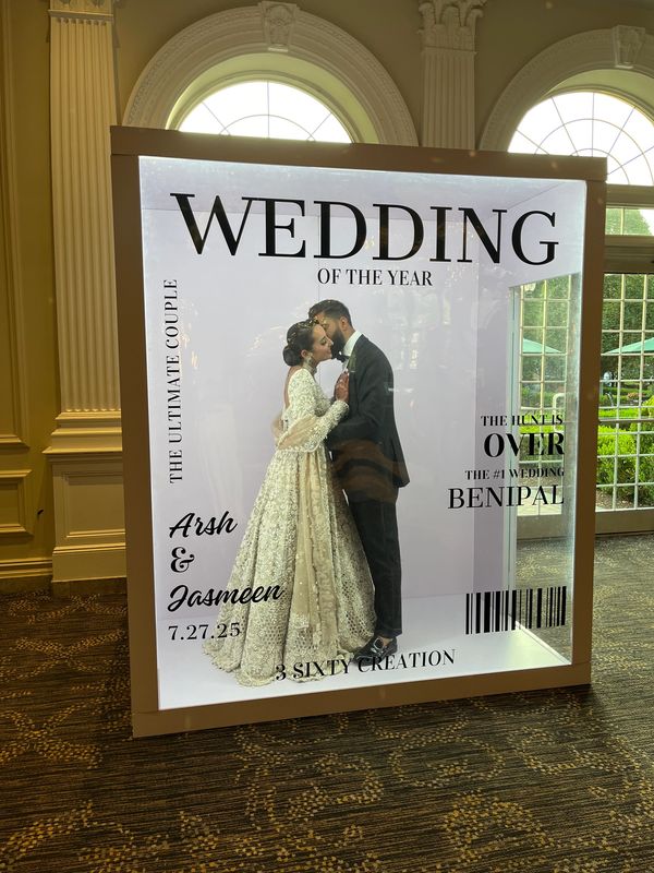 Wedding photo booth with couple posing inside a magazine frame.