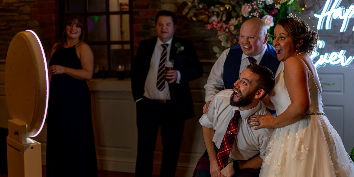 Joyful wedding guests posing for photo booth pictures.