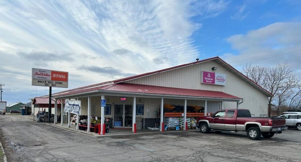 A garden supply store with a red roof and parked trucks outside.